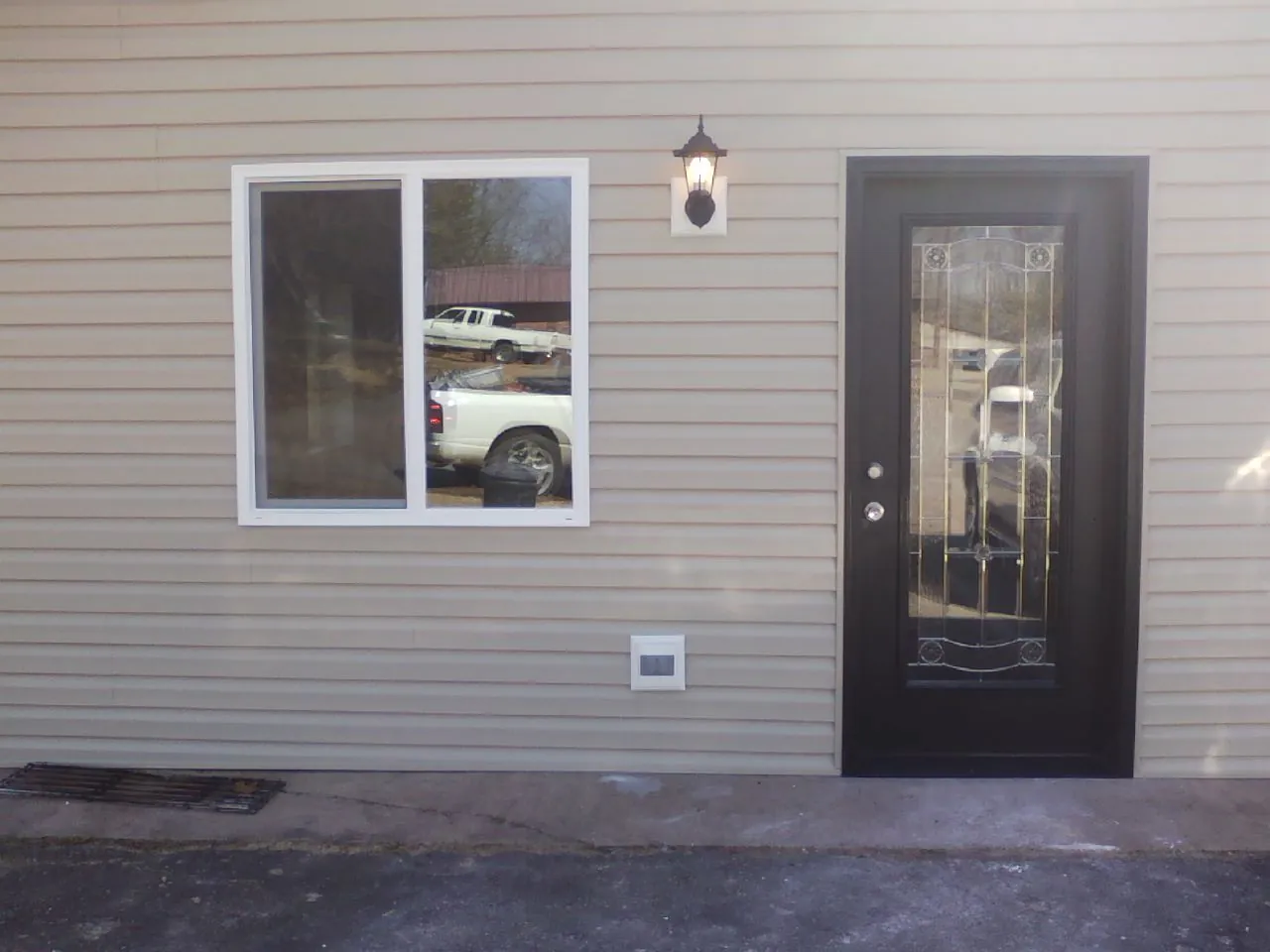 New siding, window and entry door on the side of an addition in Menno