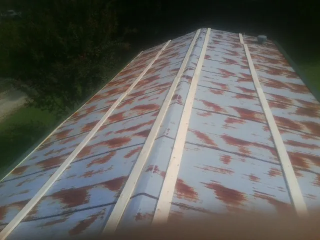 Rusted metal roof panels with new wood purlins before replacement — Storm Damage Roof Repair in Menno by Roofing Brothers