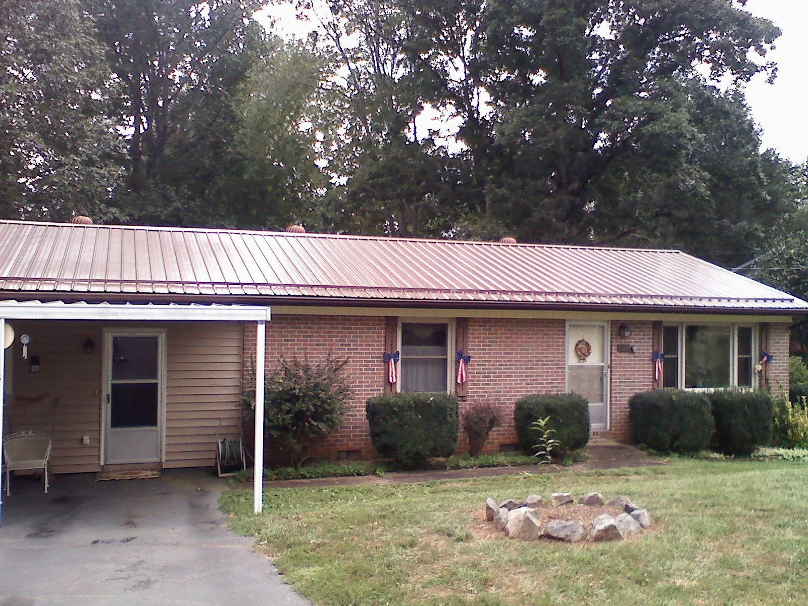 Bronze metal roof and carport on a brick ranch home — Roof Repair work by our crew in Menno